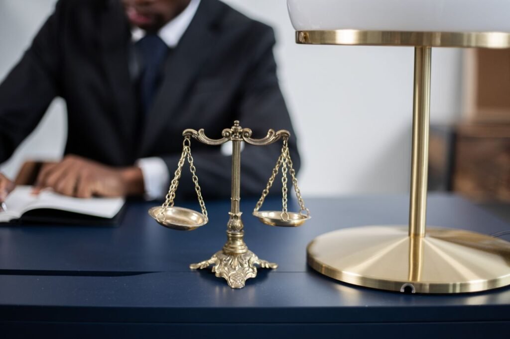 Adv. Deepak Tiwari Elegant legal office with a close-up of golden scales of justice on a sleek dark desk.